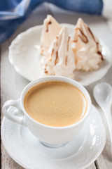 coffee and cakes of meringue on a table, selective focus