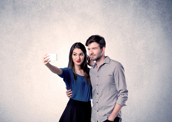 Happy couple taking selfie with clear wall