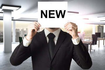 businessman hiding face behind sign new hiring