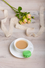 Coffee and macaron cookie on a wooden background