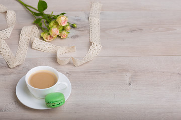 Coffee and macaron cookie on a wooden background