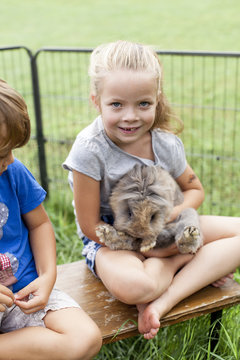 Kinder spielen mit Kaninchen