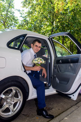 Naklejka premium Smiling man holding bouquet of flowers in car