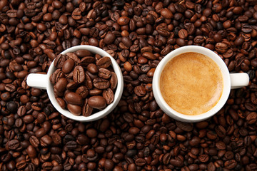 Cups with hot coffee and coffee beans, close up view