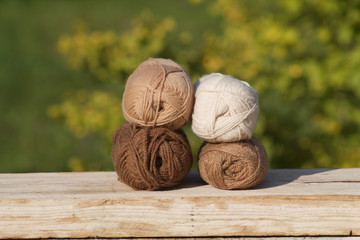 balls of wool in shades of natural tones on old wood