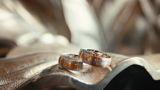 wedding rings lie in a metal vase