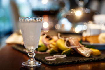 Russian vodka is poured into a frozen glass. Evening, gala dinne
