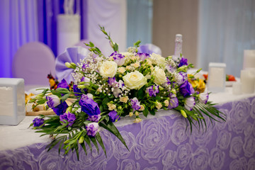 Decorative elements of a wedding table at the wedding banquet - flower composition. Wedding in lilac and violet color