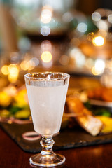 Russian vodka is poured into a frozen glass. Evening, gala dinne