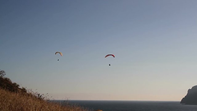 Two paraglider above the sea bay