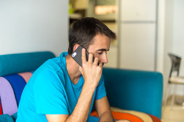 Man in an apartment talking to mobile