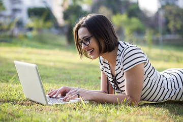 Young woman using laptop in park