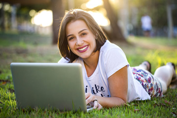 Young woman using laptop in park