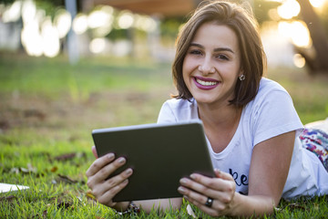 Young woman using tablet in park