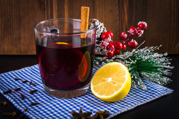 Mulled wine in a cup. Christmas set. Fruits and spices. On a wooden background.