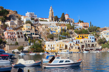 Naklejka premium Symi island - Colorful houses and small boats at the heart of the village