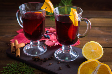 Mulled wine in a cup. Christmas set. Fruits and spices. On a wooden background.