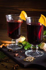 Mulled wine in a cup. Christmas set. Fruits and spices. On a wooden background.
