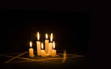 Six burning candles and the Star of David against a black background - obrazy, fototapety, plakaty