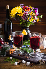 Mulled wine in a cup. Christmas set. Fruits and spices. On a wooden background.
