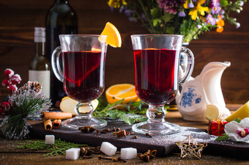 Mulled wine in a cup. Christmas set. Fruits and spices. On a wooden background.