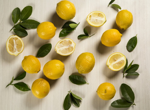 Fresh lemons on white wooden table, top view