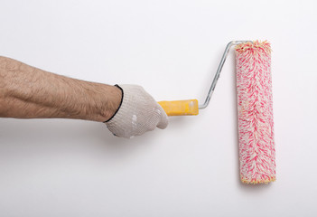 Close up of painter arm painting a wall with red paint roller