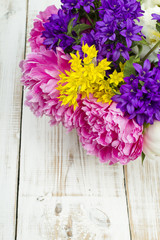 bouquet of colorful flowers on white wooden planks