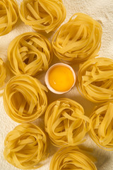 Raw homemade pasta and ingredients for pasta on wooden background