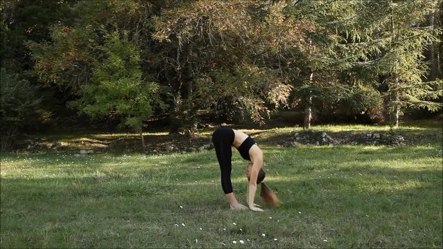 Woman doing yoga Sun Salutation posture - Surya Namaskar