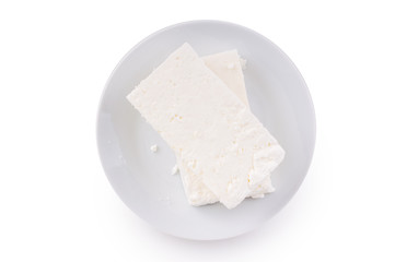 White cheese in the the saucer. On white, isolated background.Top view. Flat lay.