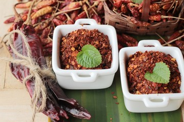 Fototapeta premium Chili powder and dried peppers on wood background.