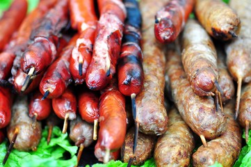 Tasty sausages on skewers made with different meats on the grill.