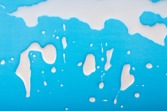 Drip of milk on a blue background.Top view. Flat lay.
