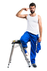 Young electrical technician with a drill making crazy gesture