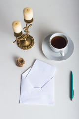 The letter and the envelope. Candles, pen and tea. On a light background.