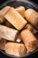 Cork stoppers in a glass. On a black background.