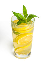 Slices of lemon in a glass with mint. On white, isolated background.