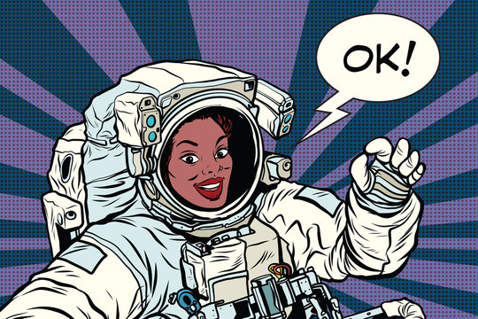 OK gesture woman astronaut in a spacesuit