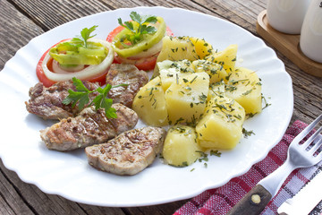 Grilled pork fillet meat and vegetables on plate