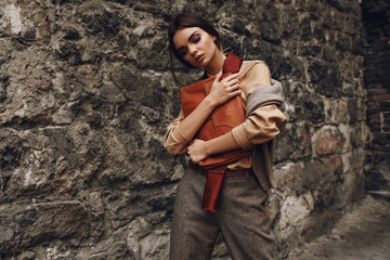 Beautiful Fashionable Woman In Fashion Clothing Posing Near Wall