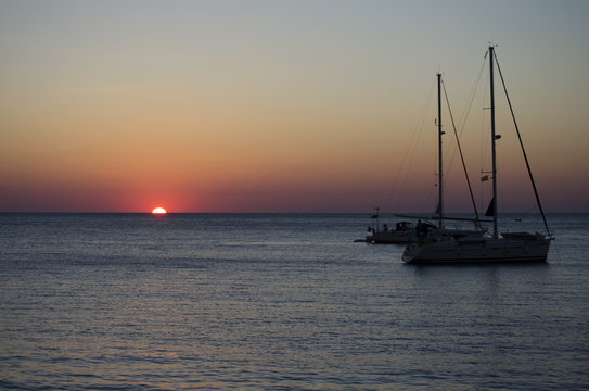 Fototapeta Silhouettes of yachts in the sea at sunset