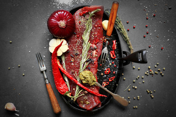 Big steak with spices in a cast iron skillet