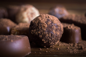 chocolate candy in cocoa on a wooden table. Macro