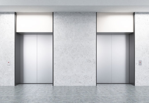 Two closed elevators in corridor with concrete walls