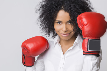 Smiling African American girl in red boxing gloves in the air