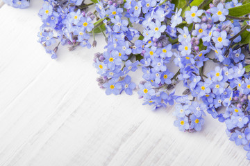 blue flowers frame on white wooden background