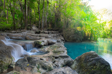 Obraz premium Jangle landscape with flowing turquoise water of Erawan cascade waterfall at deep tropical rain forest. National Park Kanchanaburi, Thailand