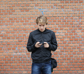 Teenage boy typing text message.Using smart phone