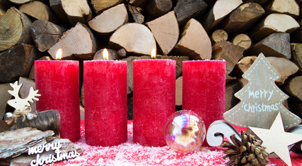 Dritter Advent / Weihnachtliche, rote Kerzen vor Holzhintergrund